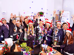 Fröhliche Gruppe von Leute in Weihnachtsmütze auf einer Weihnachtsgeschäftsparty