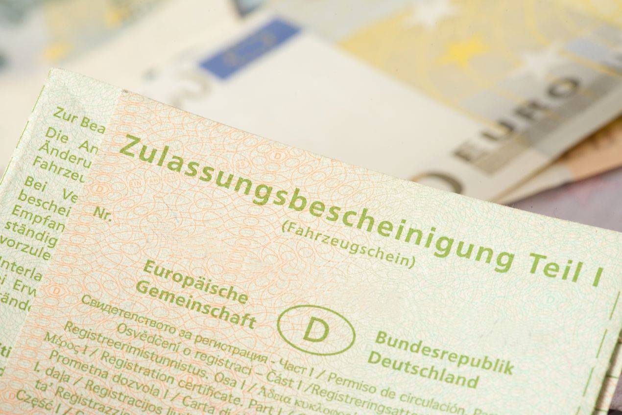 Wunschkennzeichen Mettmann wird an Auto montiert – Nahaufnahme von Händen beim Anschrauben des Nummernschilds mit Schraubenzieher