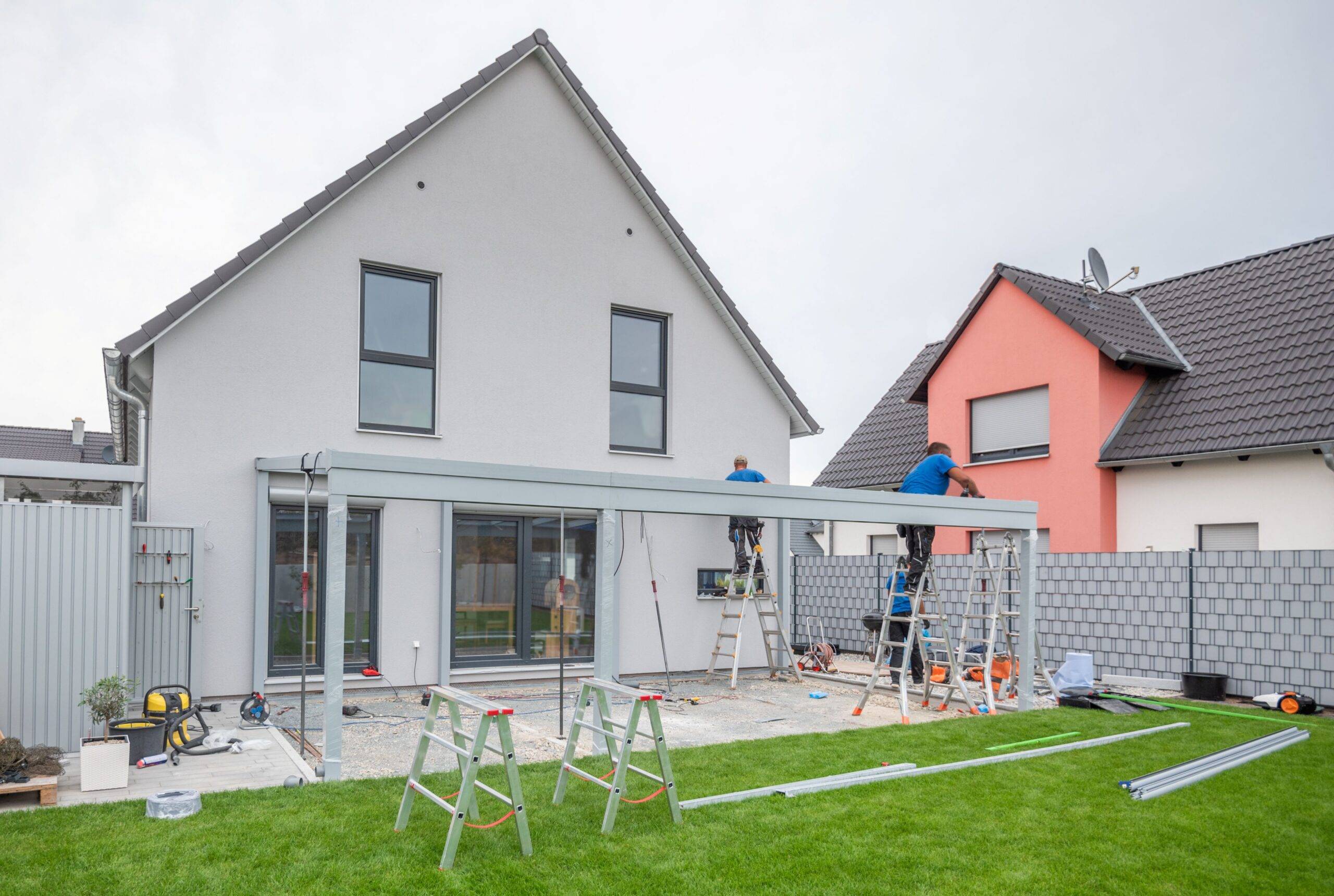 Montage einer Terrassenüberdachung an Einfamilienhaus in Düsseldorf mit Handwerkern